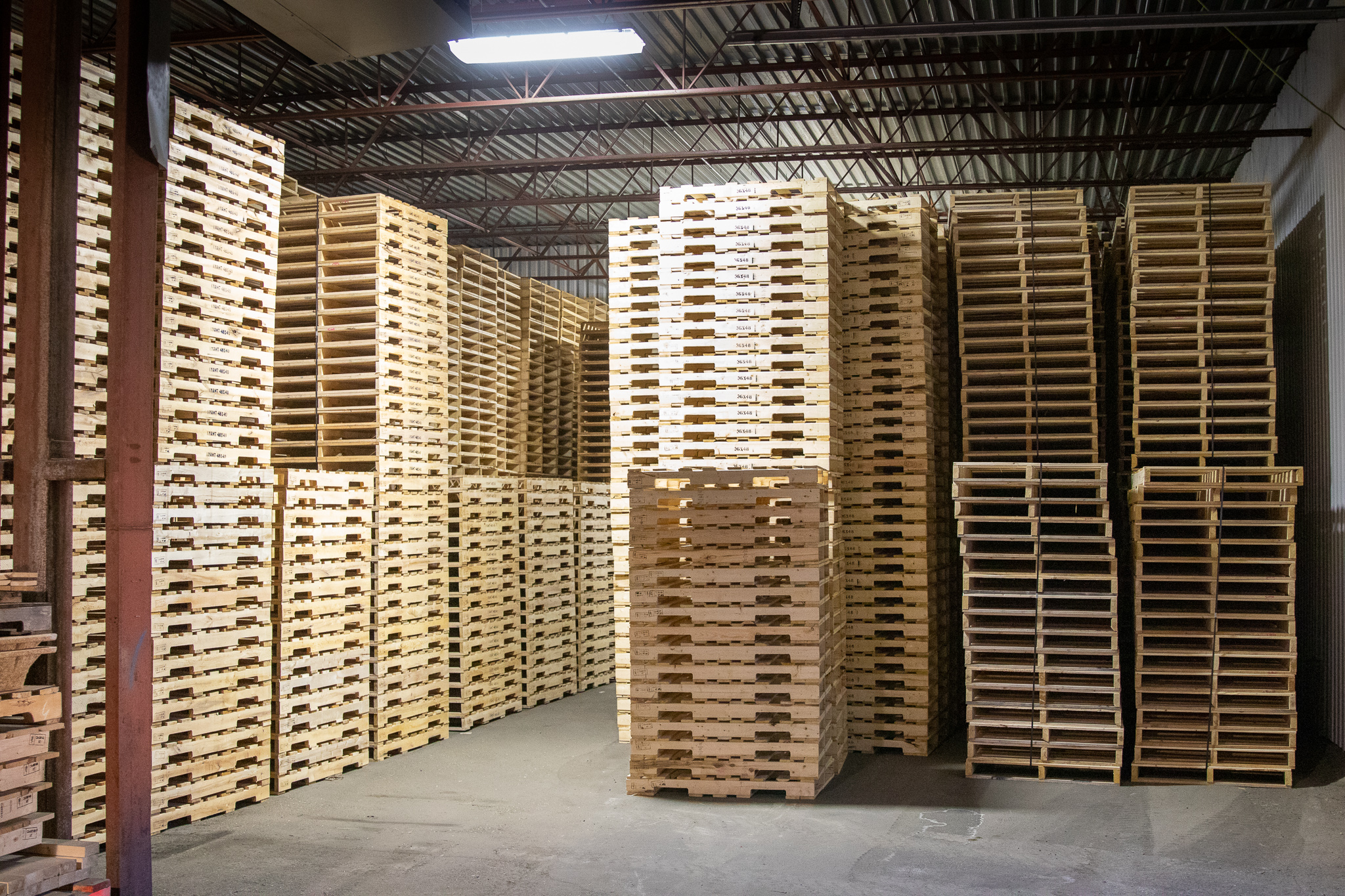 Piles de palettes en bois dans un entrepôt.