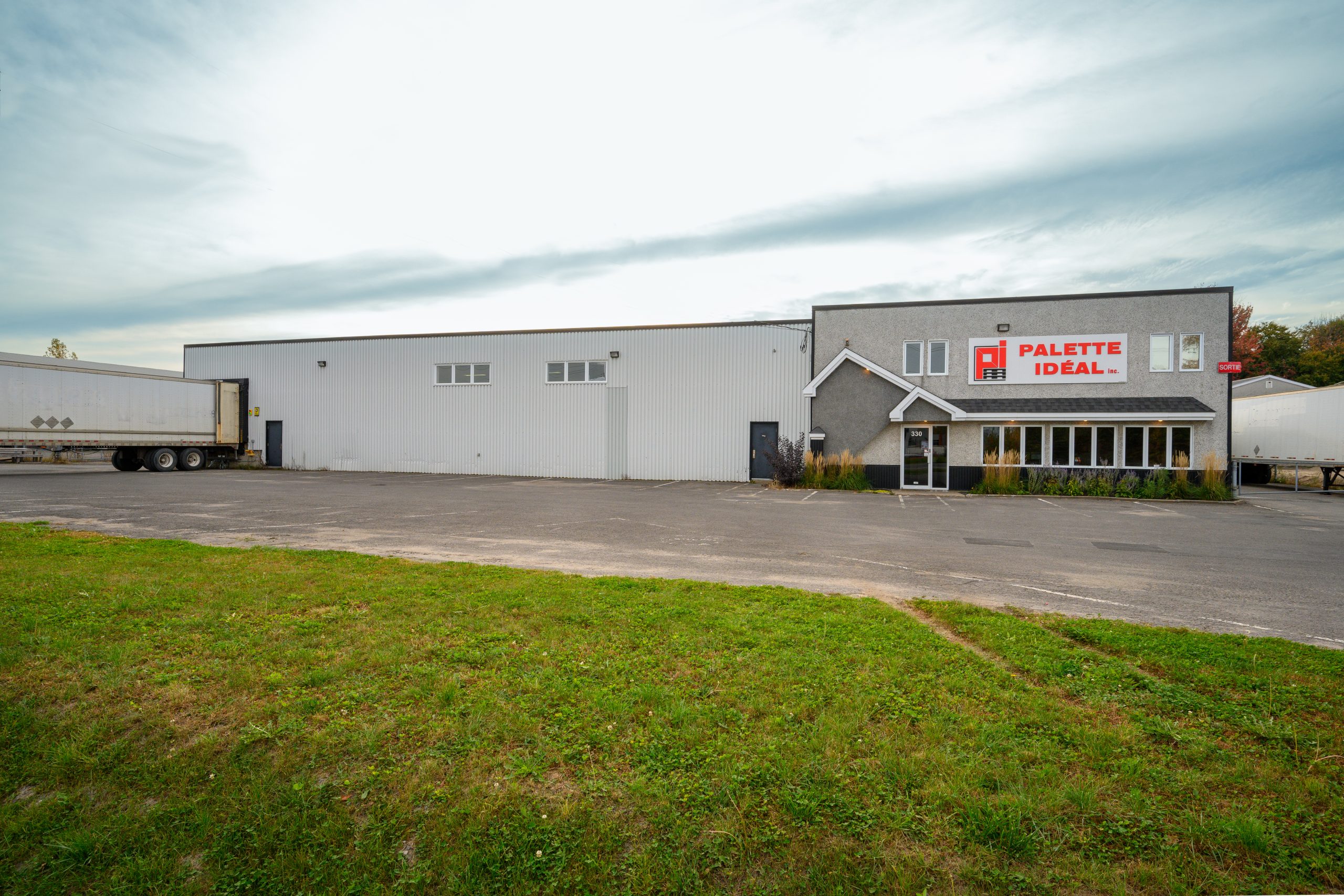 Façade d’un bâtiment industriel avec le logo Palette Idéal.